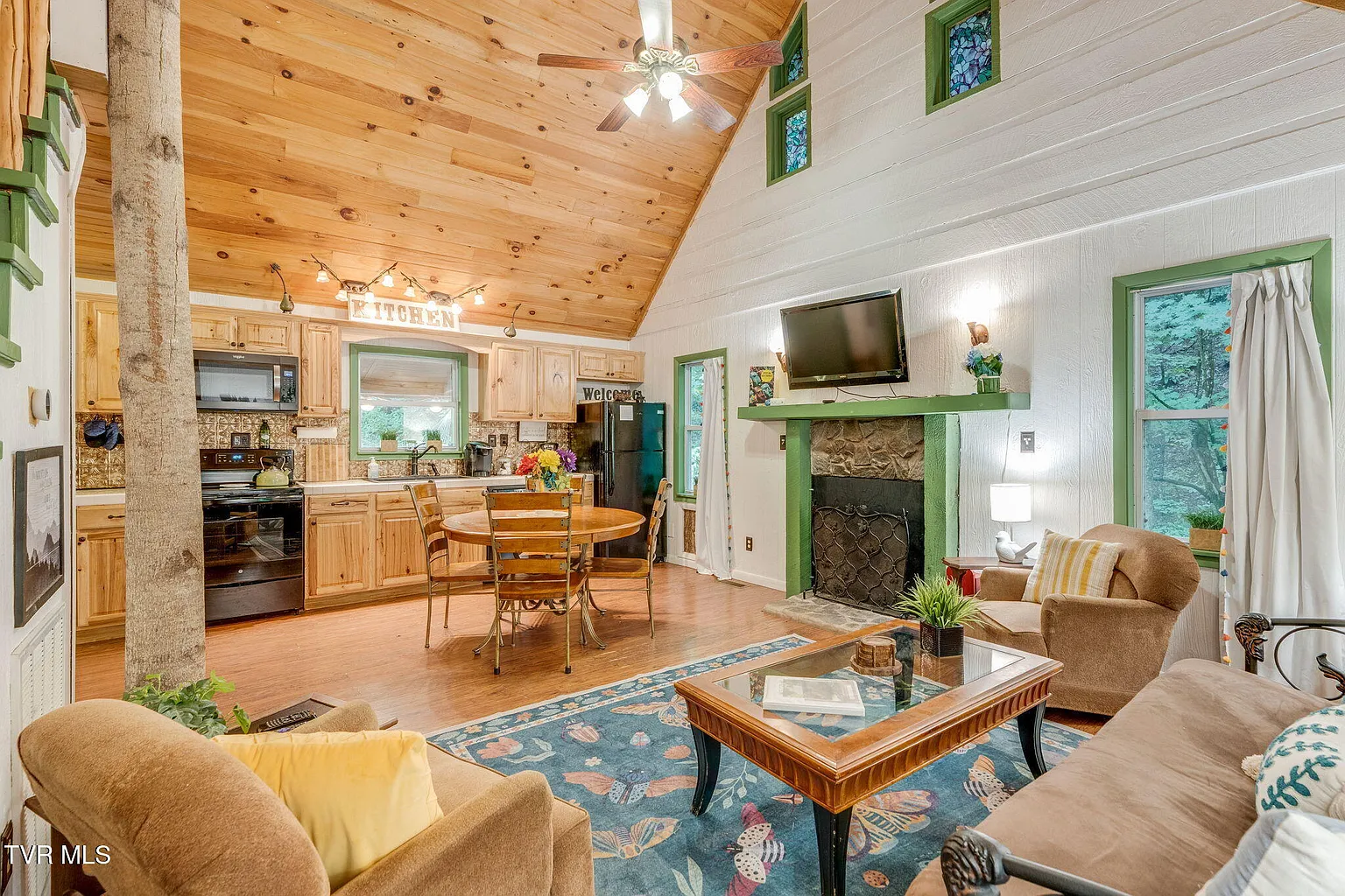 Bear cabin great room with stone fireplace and vaulted wood ceiling